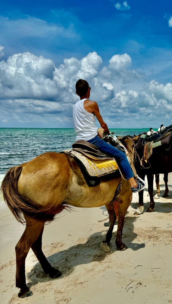 Anne Evans riding Diamond on the beach in Grand Cayman